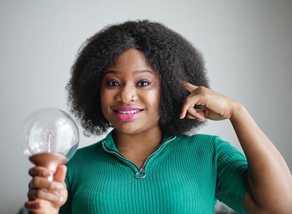 woman holding light bulb pointing to brain