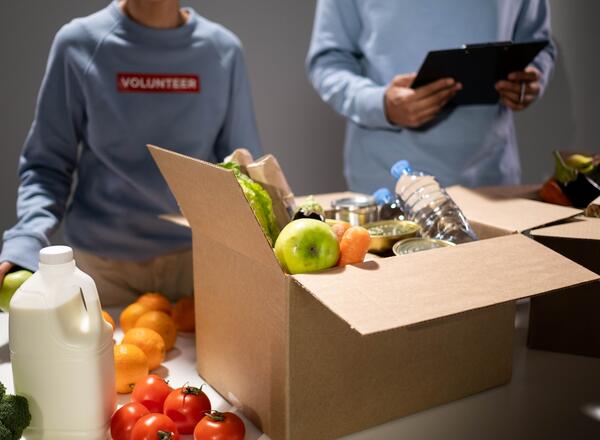 Two volunteers packing food boxes