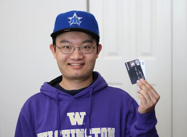 Young adult holding credit cards.
