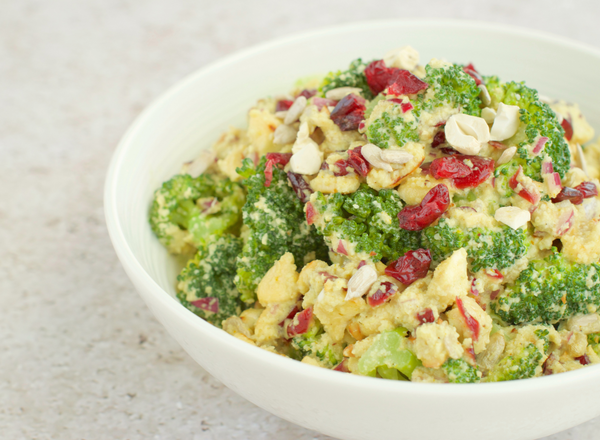Bowl of broccoli cashew salad with cranberries, apples, and pears