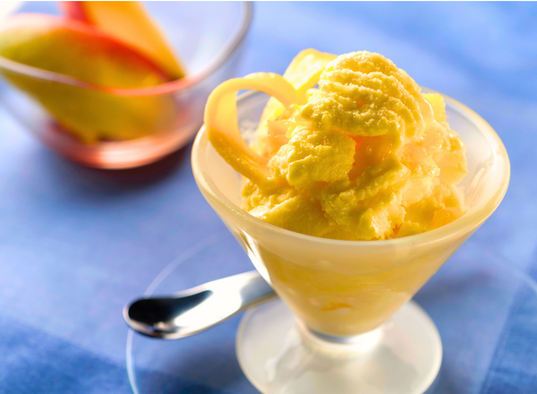 Cup of mango sorbet with a silver spoon