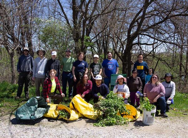 group of volunteers clearing forest of invasive garlic mustard