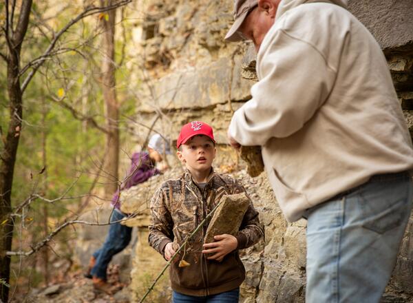 4-H Youth and Instructor search for fossils near rock formation