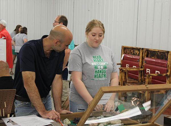 4-H General show superintendent discusses project with participant.