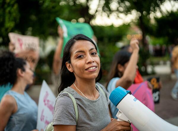 Portrait of young woman with a megaphone on a protest outdoors