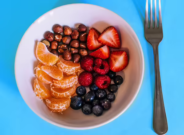 bowl of fruits including strawberries, grapes, oranges