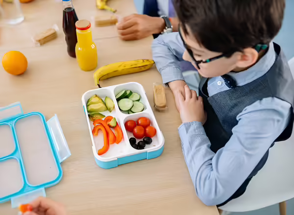 youth with school lunch of vegetables and banana