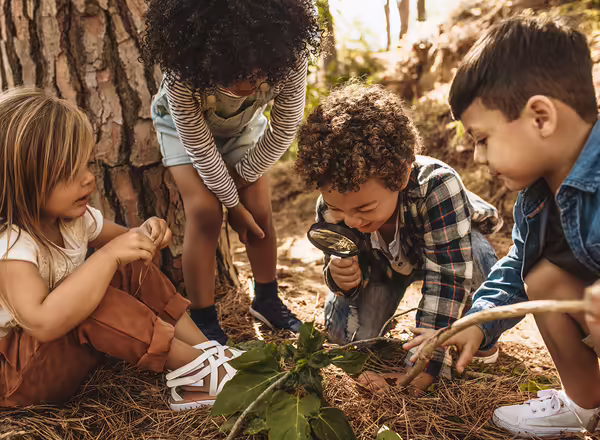 youth using magnifying glass to explore ecosystem