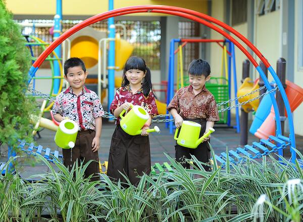 A group of kids watering plants