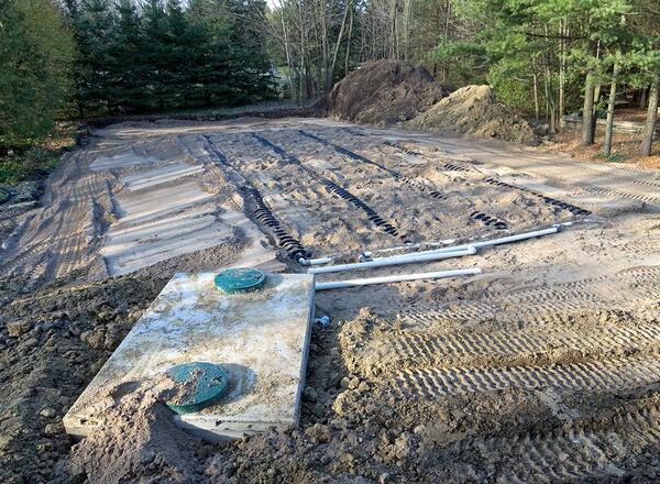 Construction site view of a septic tank and raised bed sand filled weeping bed.