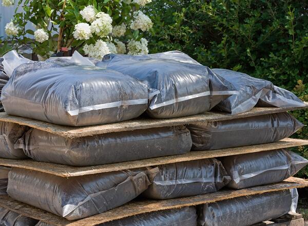 A stack of peat potting soil in plastic bags.