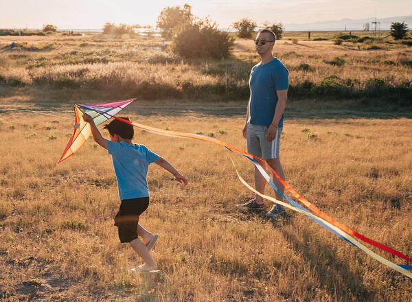 child and adult flying kites