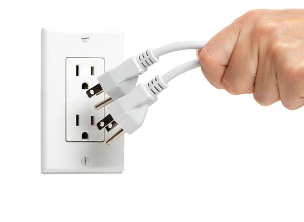 woman unplugging electrical cords on white