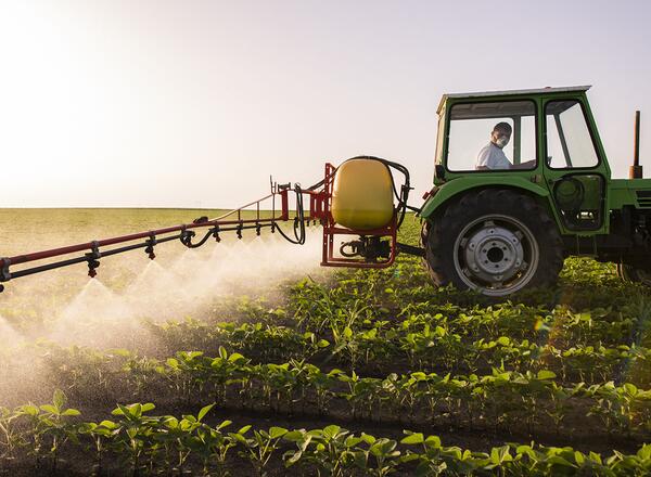 farmer spraying chemical on field