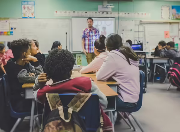 Youth in a classroom facing the front of the room.
