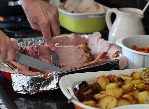 Person slicing ham