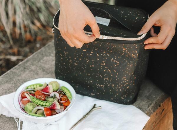 Person zipping insulated lunch box