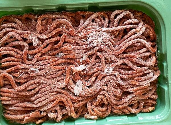 Frozen ground meat in plastic container