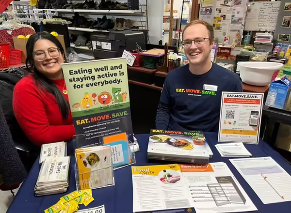 Two adults sitting behind an information booth