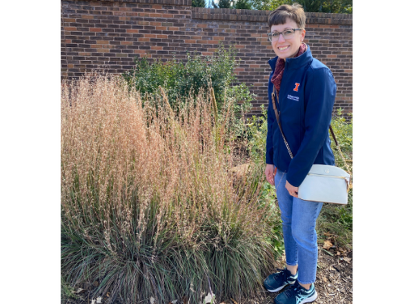 woman standing next to clump of grass