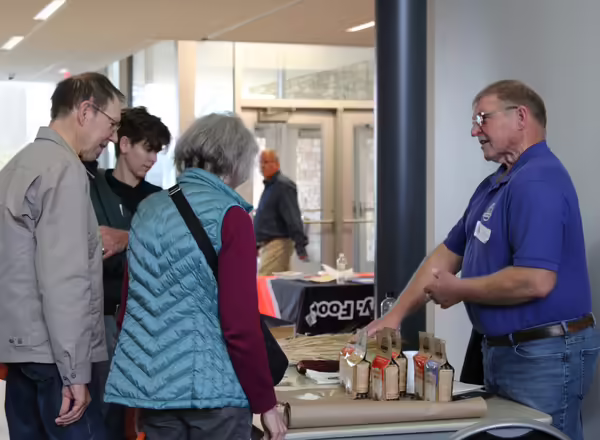 Conference attendees talking to organization tabling at event