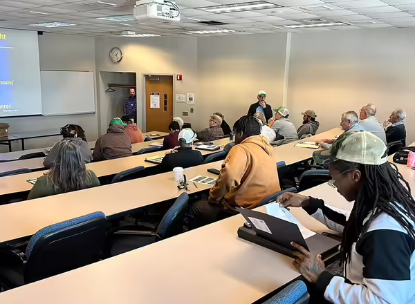 group of people sitting in a lecture hall listening to a presenter