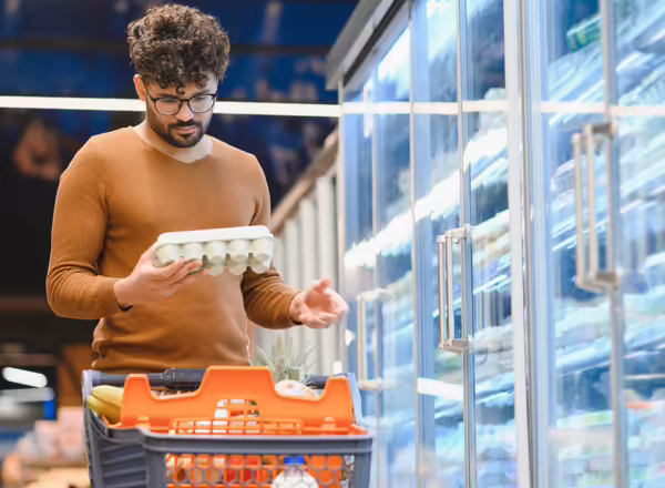 man buying catron of eggs at grocery store