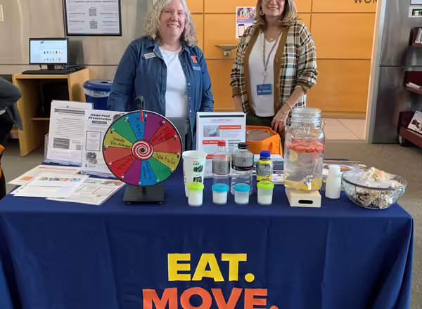Two women standing behind an educational table