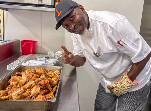 Chef Adonis Jackson next to wings made with IL-EATS chicken