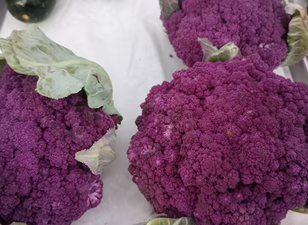 purple cauliflowers laying on a vending table
