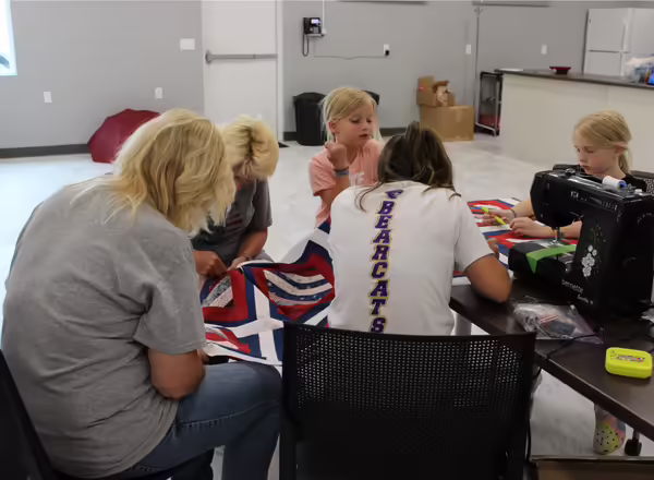 Youth and adults sew a Quilt of Valor for a local veteran during a hands-on workshop at the Washington County Extension Office.