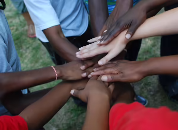 The Eden Place community shows teamwork by stacking their hands on top of each other