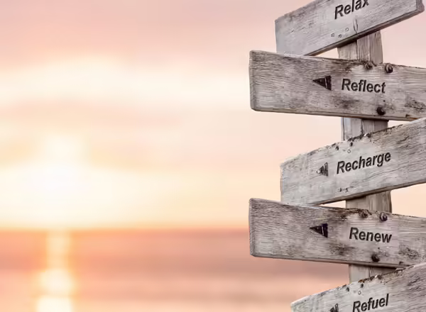 directional sign in front of sunset over beach