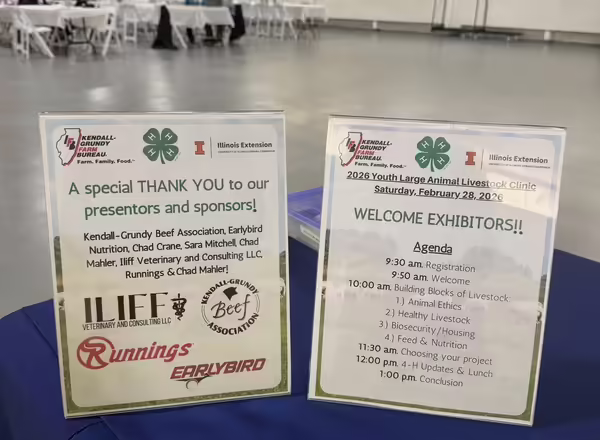 Two table signs on a blue table which showcases the schedule for the days events