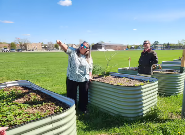 Nancy Kuhajda and Matthew Vann view garden beds. Nancy points to something off camera