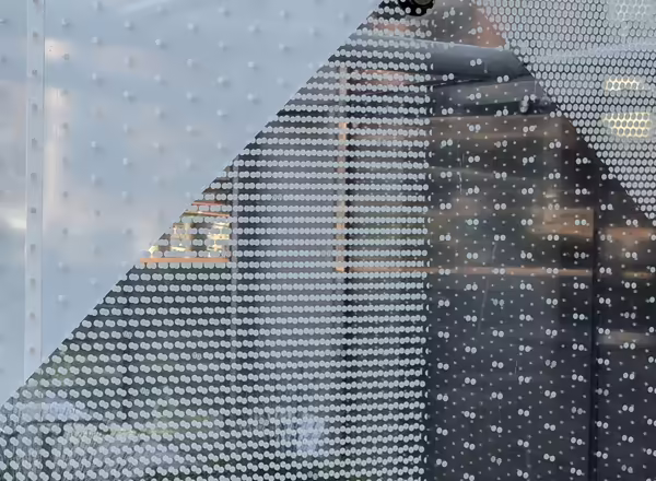 Glass wall with white dots in three different patterns that vary in the proximity of the dots