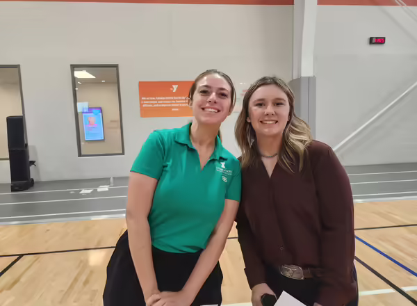 Two adults, one wearing a green 4-H polo, pose for a picture