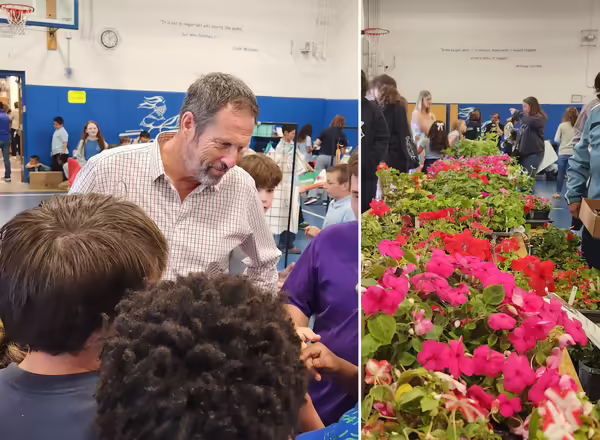 An adult talks to a group of kids while on the right is a row of flowers on a table