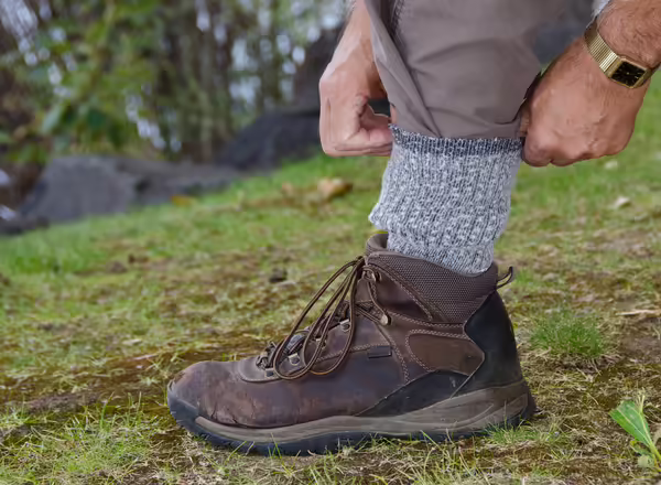 A person tucks their pants into their socks