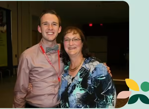Kevin Carey stands with his mentor Deb Stocker. They are both smiling.