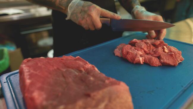 food being cut on a blue cutting board