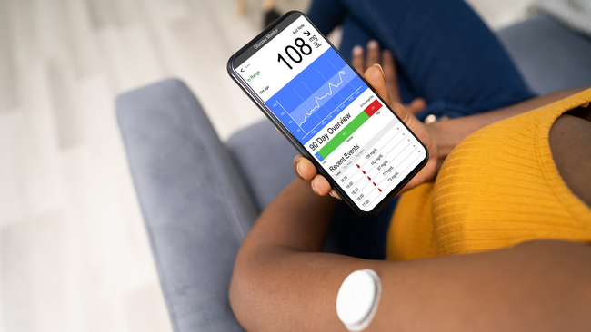 Image of woman checking phone diabetes app