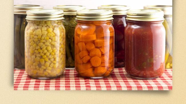 Corn, carrots and sauce in glass jars