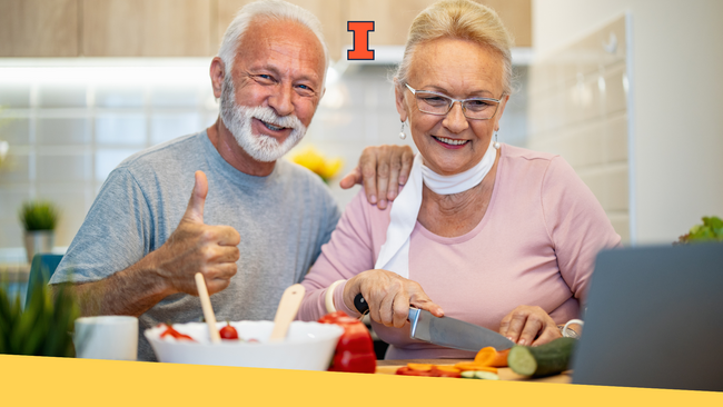 A senior couple talking and smiling while preparing food together in a kitchen.