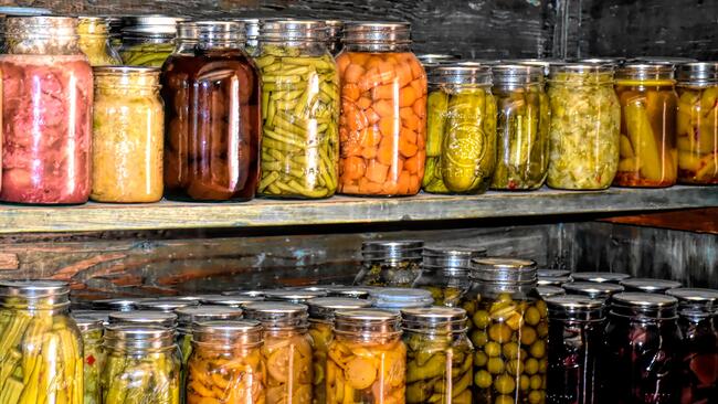 2 rows of jars with preserved vegetables