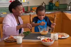 mother with son preparing breakfast at a table