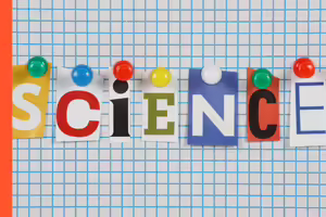 the letters spelling science pinned to a graph paper