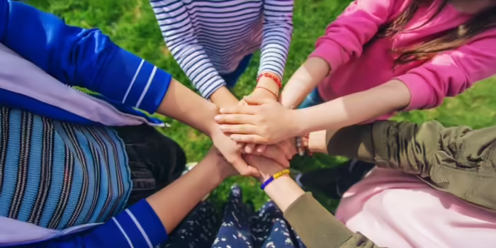 Multiple young hands holding each other 
