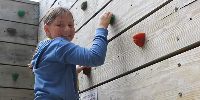 girl smiling on climbing wall