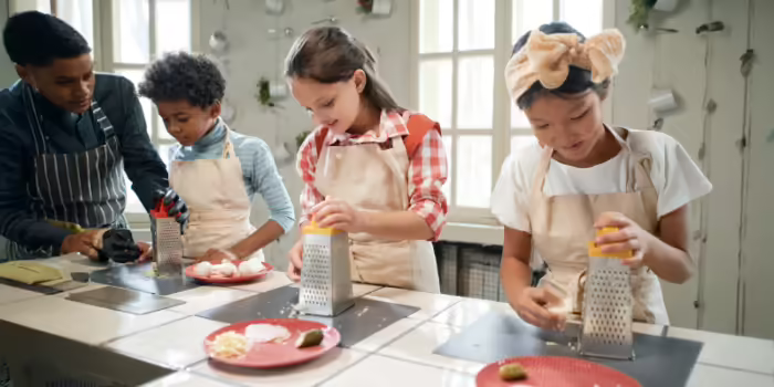 A group of children learning how to cook 